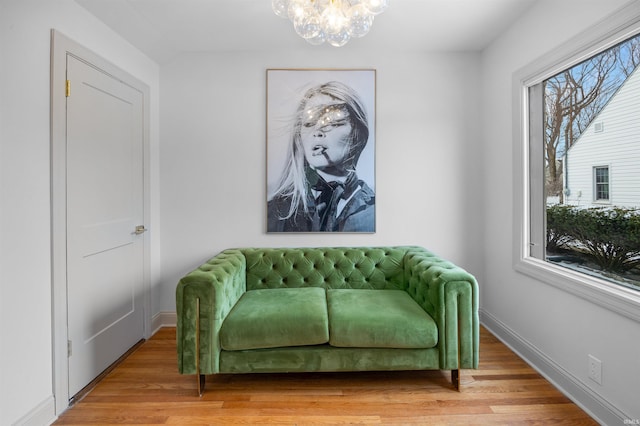 living area with a chandelier, wood finished floors, and baseboards