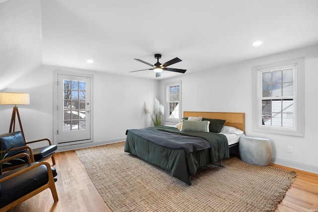 bedroom with light wood-type flooring, access to outside, multiple windows, and baseboards