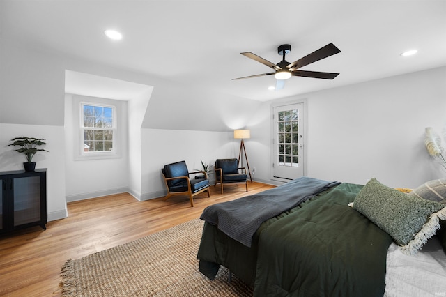 bedroom featuring light wood-type flooring, multiple windows, lofted ceiling, and baseboards