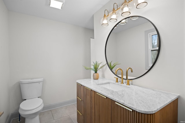 half bathroom with toilet, an inviting chandelier, vanity, tile patterned flooring, and baseboards