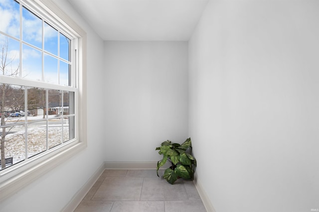 interior space featuring light tile patterned floors and baseboards