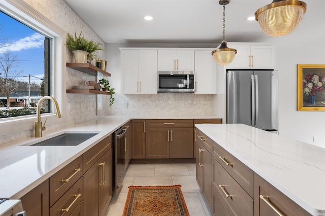 kitchen with stainless steel appliances, white cabinets, a sink, and open shelves