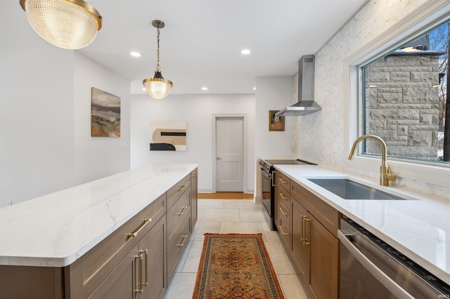 kitchen featuring light stone countertops, wall chimney exhaust hood, appliances with stainless steel finishes, and a sink