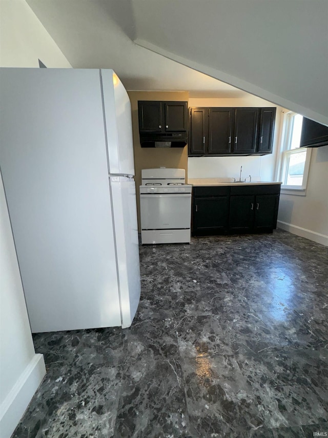 kitchen featuring vaulted ceiling, light countertops, white appliances, and baseboards