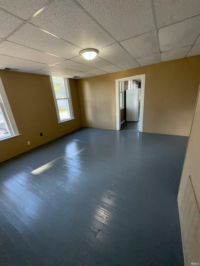 empty room featuring a paneled ceiling and dark wood-type flooring