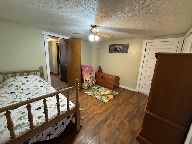 bedroom featuring dark wood-style flooring, ceiling fan, a textured ceiling, and baseboards