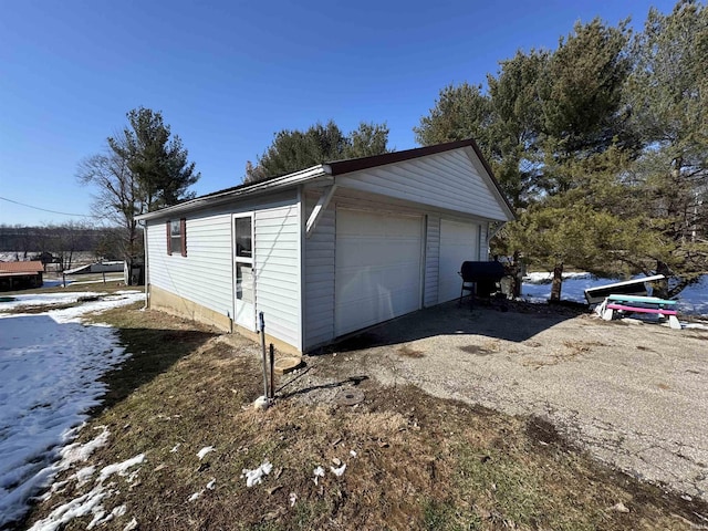 snow covered garage featuring a detached garage