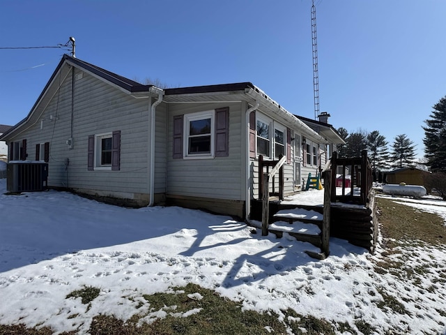 snow covered property with cooling unit