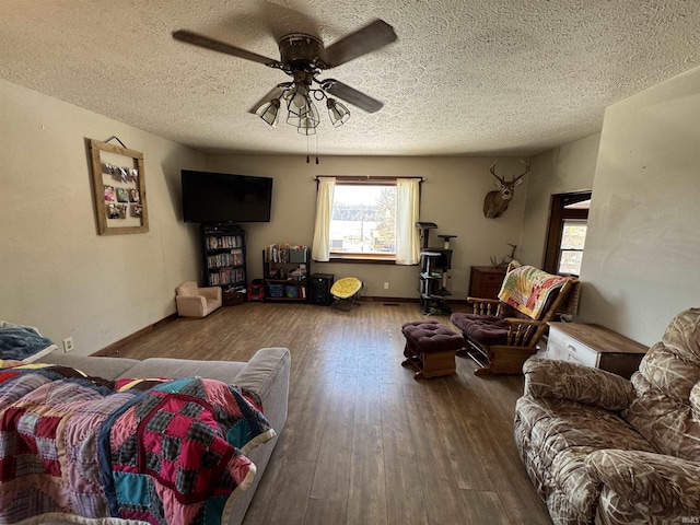 living room featuring a textured ceiling, wood finished floors, a ceiling fan, and baseboards