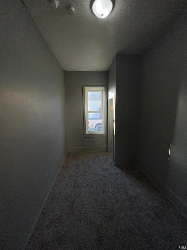 unfurnished room featuring carpet floors and baseboards