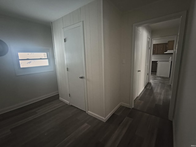 hallway with dark wood-style floors, washer / clothes dryer, and baseboards