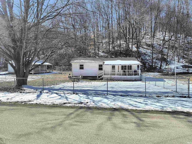 view of front of property with metal roof, fence, and a sunroom