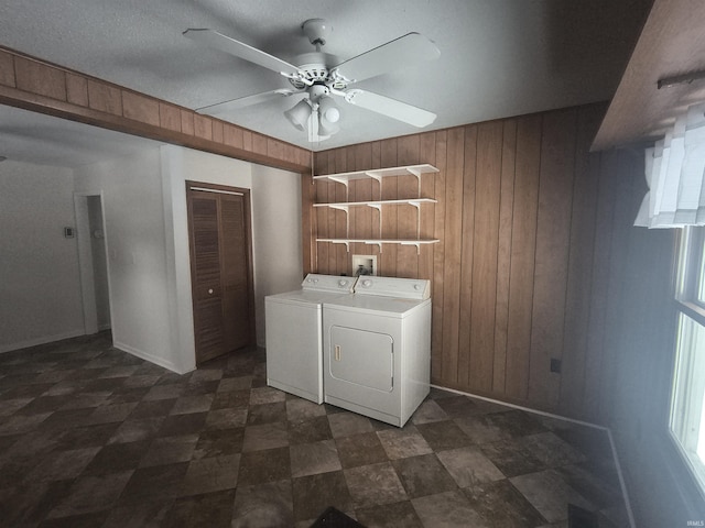 washroom with a ceiling fan, laundry area, wood walls, and washer and clothes dryer