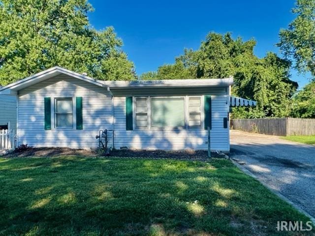 view of front of property with a front lawn, fence, and aphalt driveway