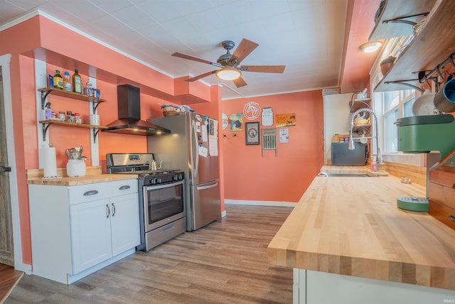 kitchen featuring range hood, open shelves, stainless steel appliances, white cabinets, and butcher block countertops