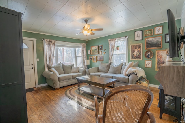 living room with a healthy amount of sunlight, ornamental molding, and wood finished floors