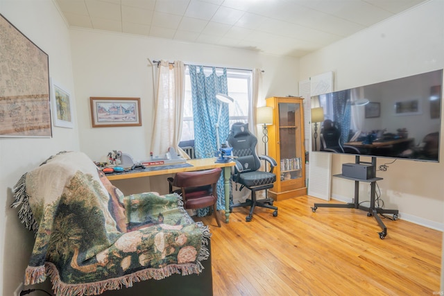 home office with ornamental molding, wood finished floors, and baseboards