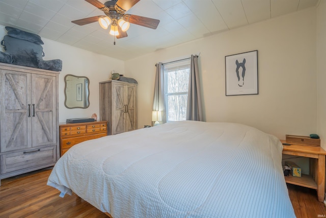 bedroom with ceiling fan, dark wood-type flooring, and crown molding