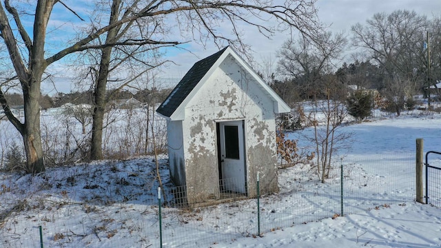 snow covered structure with a shed and an outbuilding