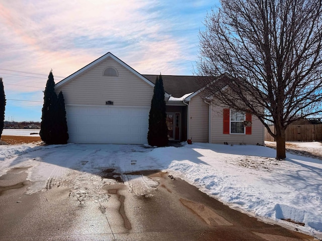 ranch-style home with a garage and fence