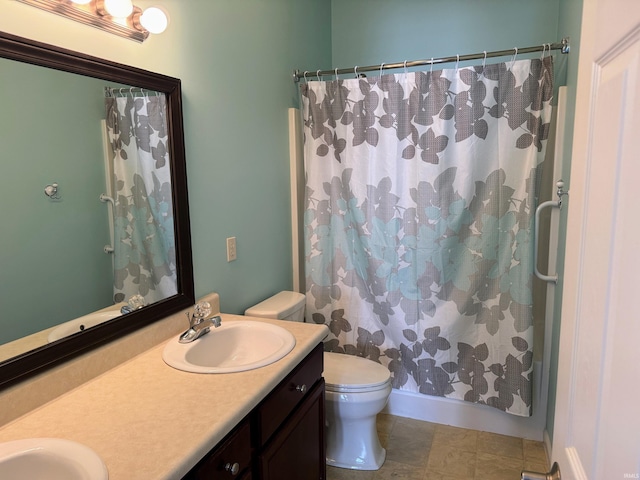 bathroom featuring double vanity, curtained shower, a sink, and toilet