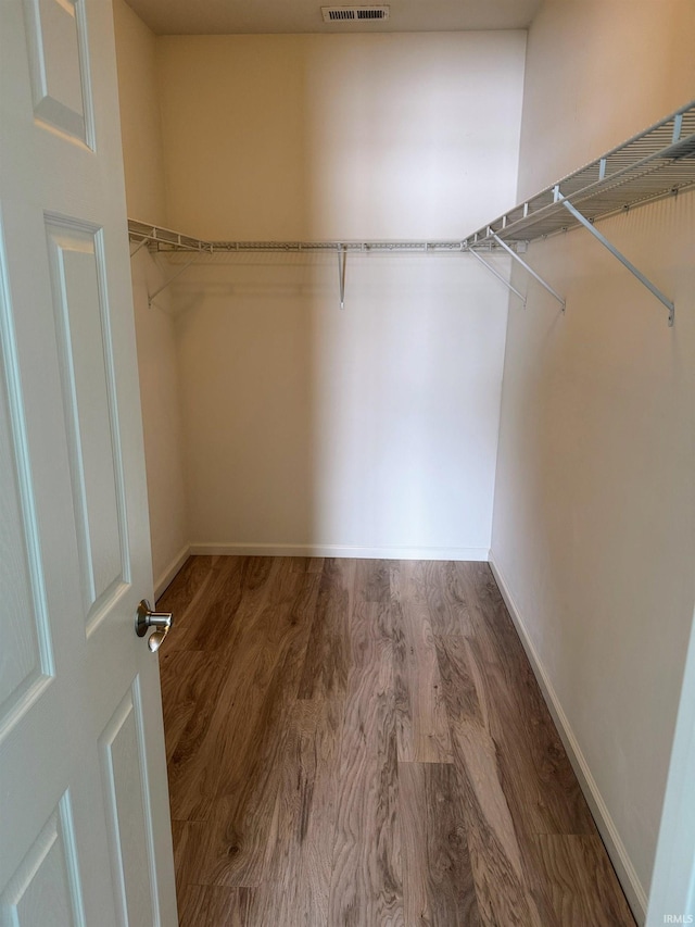 spacious closet featuring visible vents and wood finished floors