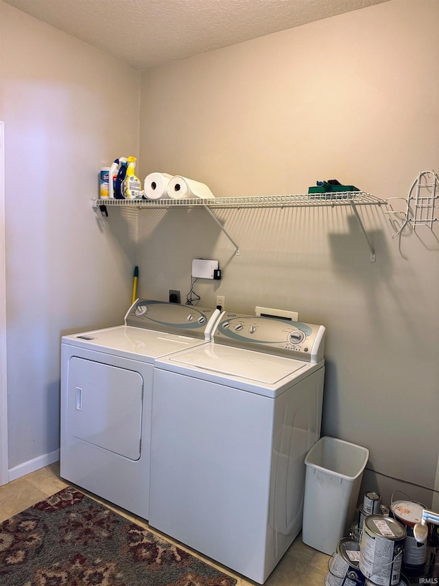 laundry area featuring laundry area, light tile patterned floors, baseboards, and washer and dryer