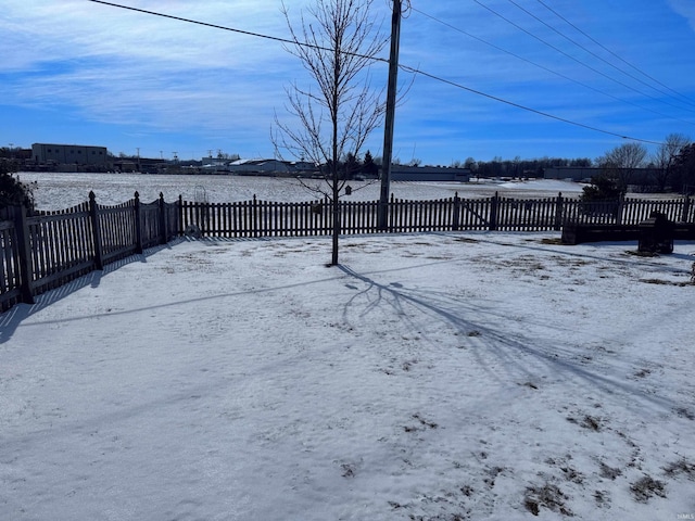 snowy yard with a fenced front yard