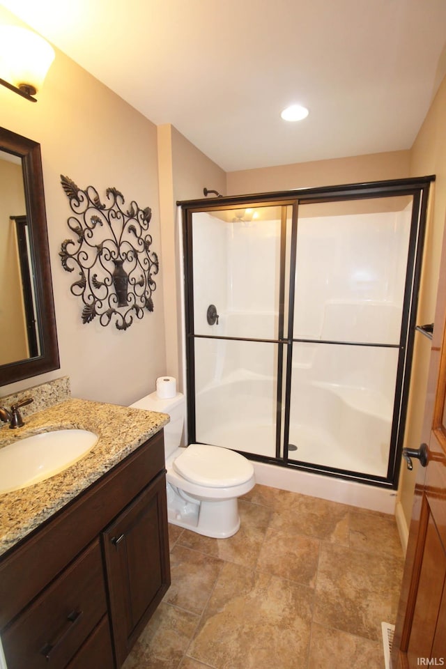 full bathroom with toilet, a shower stall, and vanity