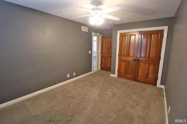 unfurnished bedroom with carpet floors, a ceiling fan, visible vents, baseboards, and a closet