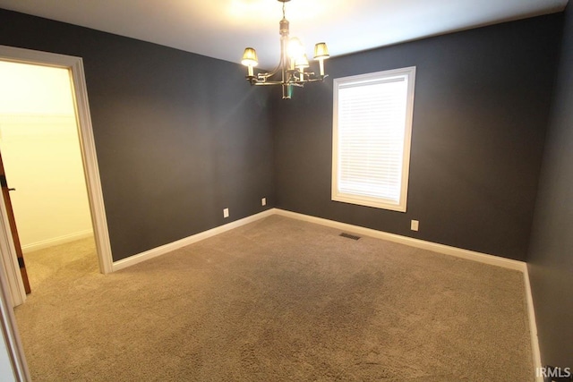 carpeted empty room featuring visible vents, baseboards, and an inviting chandelier