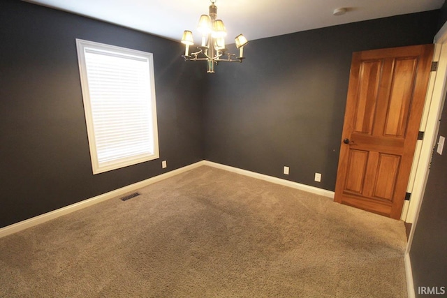 empty room featuring visible vents, baseboards, a chandelier, and carpet flooring