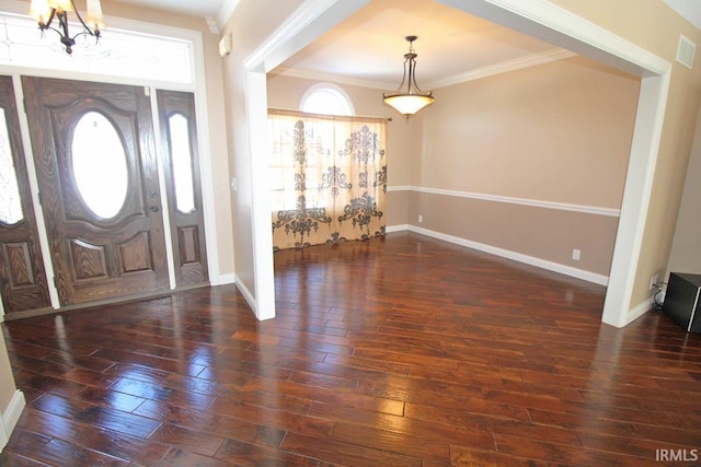 foyer entrance with dark wood-style floors, a notable chandelier, baseboards, and crown molding