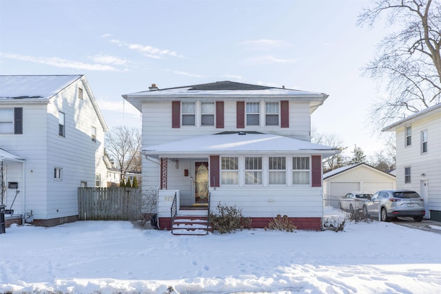 american foursquare style home featuring a detached garage and fence