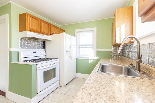 kitchen with under cabinet range hood, white range with gas cooktop, light countertops, and a sink