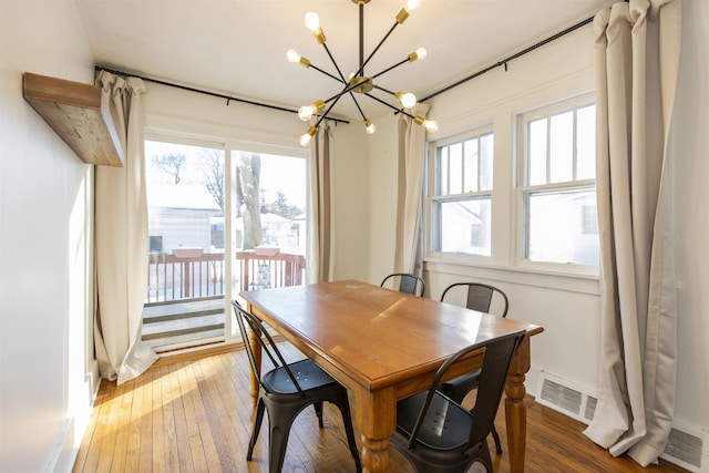 dining room with visible vents, plenty of natural light, and wood finished floors