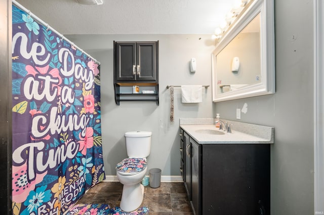 full bath featuring baseboards, a shower with shower curtain, toilet, a textured ceiling, and vanity