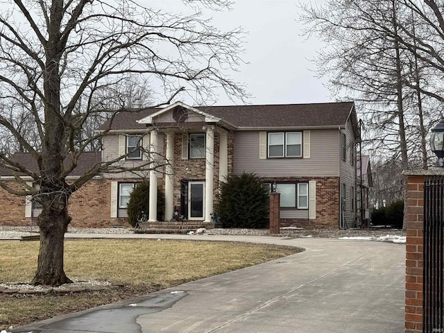 view of front facade featuring a front yard and brick siding