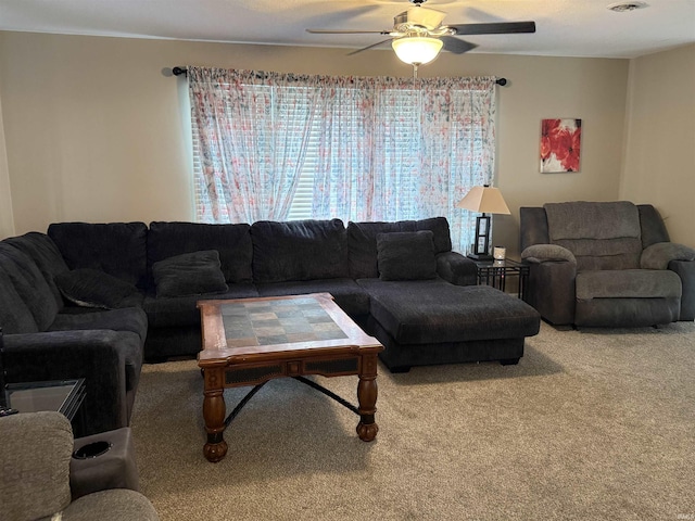 carpeted living area with visible vents and a ceiling fan