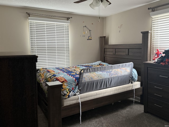 carpeted bedroom with a ceiling fan and a textured ceiling