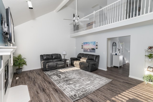 living room featuring a premium fireplace, wood finished floors, beam ceiling, and baseboards