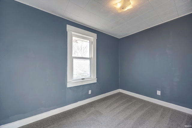 spare room featuring baseboards and carpet flooring