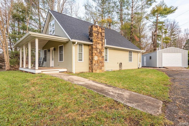 view of side of home with an outbuilding, roof with shingles, a detached garage, a chimney, and covered porch