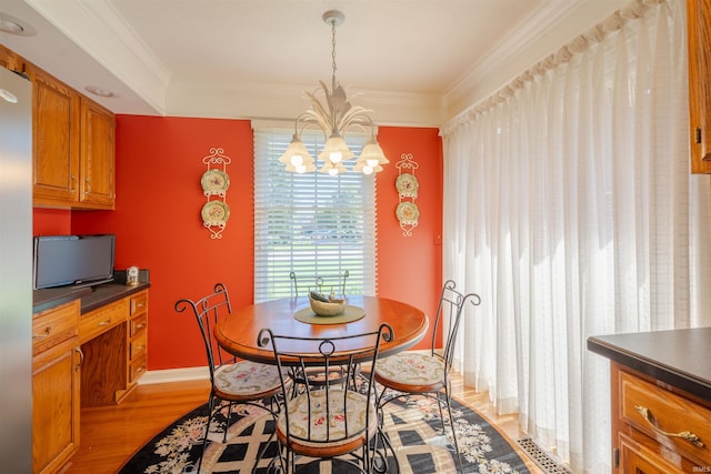 dining room featuring a notable chandelier, baseboards, light wood-style flooring, and crown molding