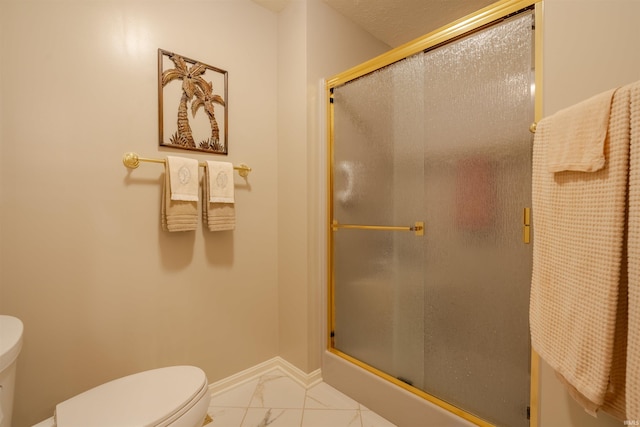 bathroom featuring marble finish floor, a shower stall, toilet, and baseboards