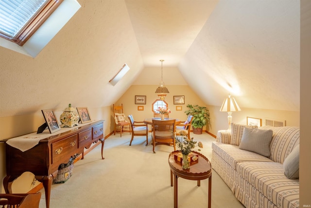 living area featuring lofted ceiling with skylight, light colored carpet, visible vents, and baseboards