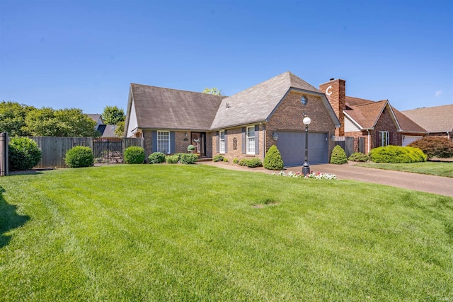 view of front of house featuring a front yard, brick siding, fence, and an attached garage