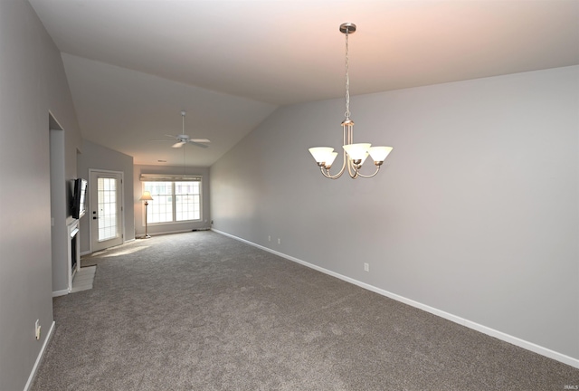 empty room with lofted ceiling, ceiling fan with notable chandelier, dark carpet, and baseboards
