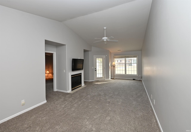 unfurnished living room featuring lofted ceiling, a fireplace with flush hearth, baseboards, and ceiling fan