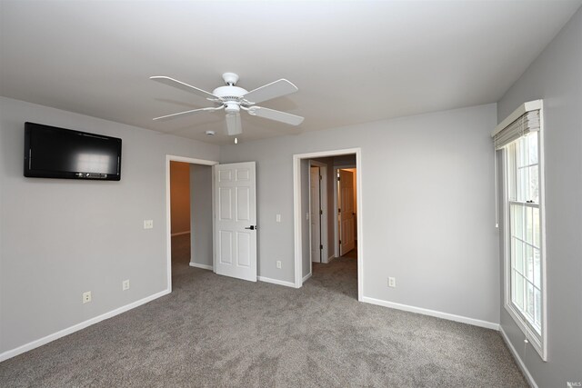 unfurnished bedroom with carpet floors, multiple windows, ceiling fan, and baseboards